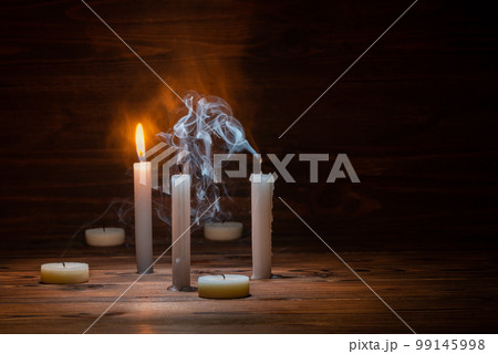burning and extinct candles with smoke on wooden burning and extinct candles with smoke on wooden 99145998