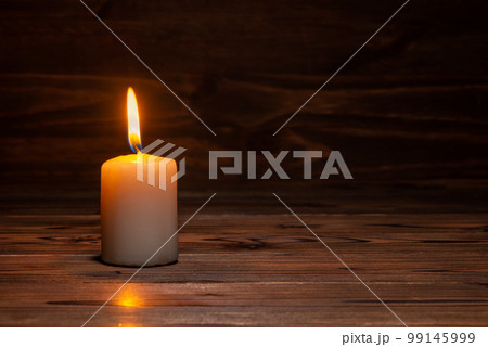 burning candle on wooden background 99145999