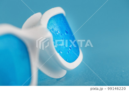 White swimming goggles on a blue background 99146220