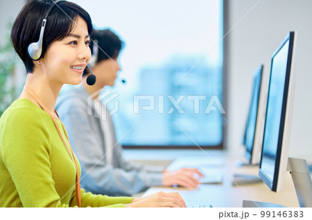 オフィスでヘッドセットをつけて対応するオペレーターの女性 99146383