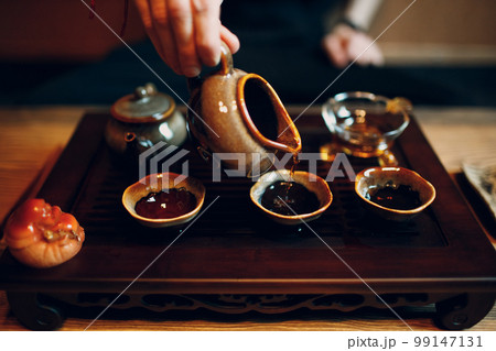 Chinese traditional puerh tea ceremony. Shepherd, chahay and gaiwan pour shu puehr to cup 99147131