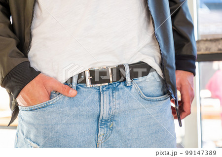 Man wearing jacket and jeans with stylish black leather belt. Close-up of craft accessory. Fashion and casual modern style 99147389