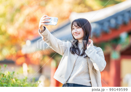 旅行中にスマホで自撮りする女性 99149599