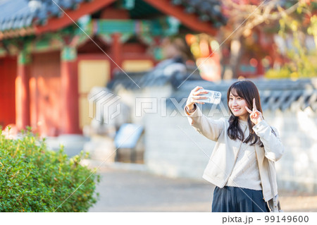 旅行中にスマホで自撮りする女性 旅行中にスマホで自撮りする女性 99149600