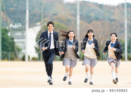 校庭を走る女子高生と男子学生 99149892