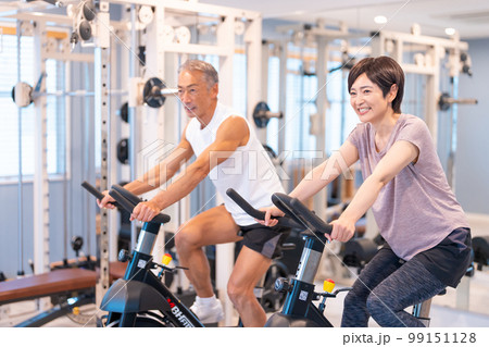 スポーツクラブでエアロバイクをするミドル夫婦 スポーツクラブでエアロバイクをするミドル夫婦 99151128