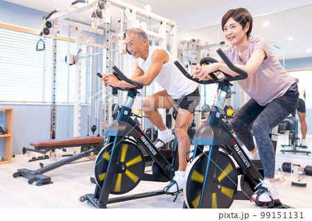 スポーツクラブでエアロバイクをするミドル夫婦 99151131