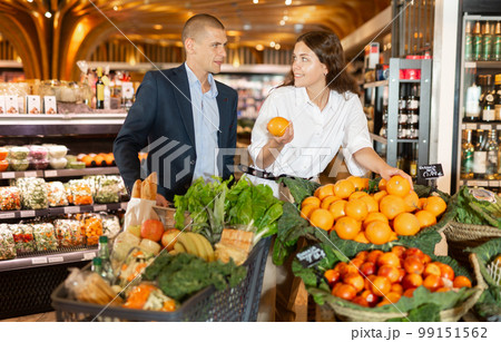 Couple shopping at vegetables department at supermarket 99151562