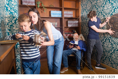 Friendly family is trying to find a solution to the puzzle in the quest room Friendly family is trying to find a solution to the puzzle in the quest room 99151639