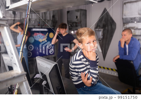 Close-knit family with children thinks, trying to find a solution to the puzzle in the quest room, to get out of there Close-knit family with children thinks, trying to find a solution to the puzzle in the quest room, to get out of there 99151750