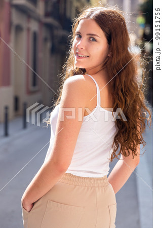 Cheerful attractive female walking on street outdoor 99151756