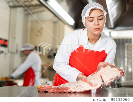 Female seller demonstrating meat in butcher shop Female seller demonstrating meat in butcher shop 99152060