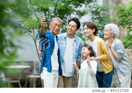 スマホで自撮りをする三世代家族 スマホで自撮りをする三世代家族 99152789