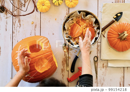 エプロン姿の女性が作るハロウィンのジャックオーランタン　ハロウィンのランタンの作り方 99154218