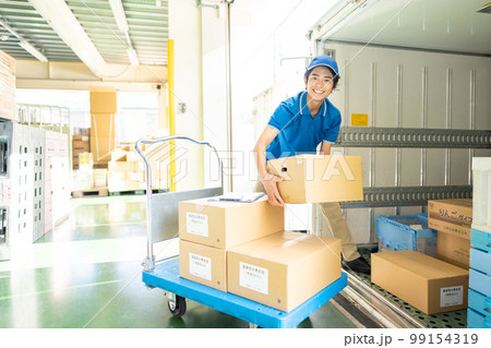 トラックに荷物を積み込むドライバーの男性 99154319