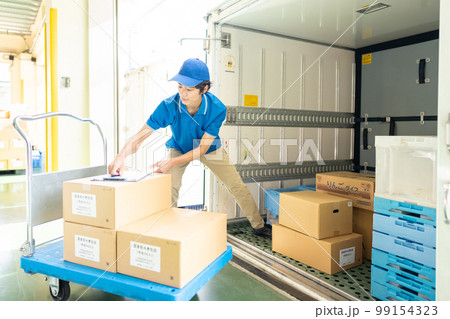 トラックに荷物を積み込むドライバーの男性 99154323