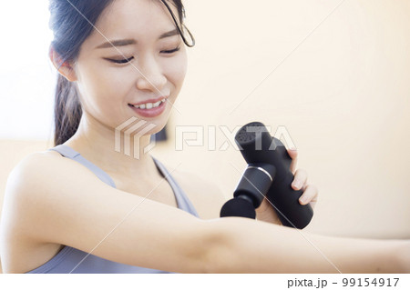 トレーニング後、筋膜リリースガンを使う若い女性 トレーニング後、筋膜リリースガンを使う若い女性 99154917