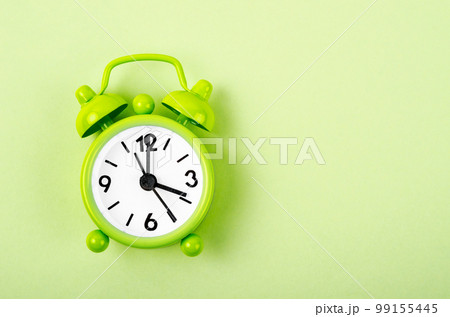 The Green alarm clock on green colour background. The Green alarm clock on green colour background. 99155445