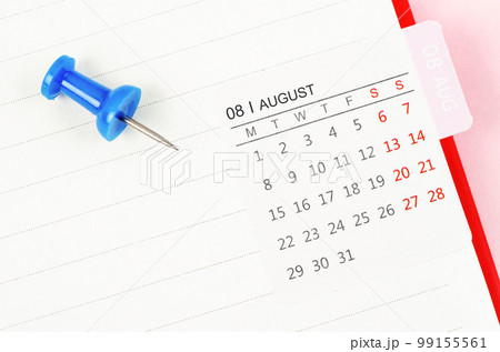 The Mini August calendar on a white note book with push pin on pink colour background. 99155561