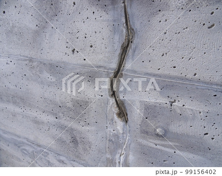 コンクリート擁壁のクラック補修(Vカット施工状況)※クラックから漏水による滲み 99156402