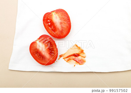 Tomatoes and ketchup stain on white shirt clothes on a beige background 99157502