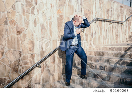 Portrait of a senior professional man in a suit with various problems. A middle-aged businessman with descends the stairs. 99160063