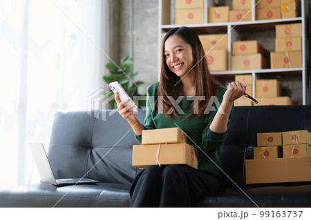 Beautiful Businesswoman start small business. A woman works from home delivering parcels online. Entrepreneurs, SME delivery concept 99163737