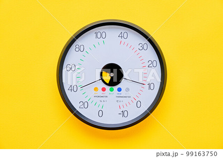 黄色背景の上の温度湿度計 99163750