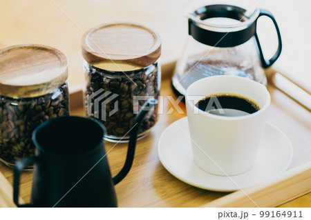 テーブルの上の一杯のコーヒーとコーヒーセット 99164911