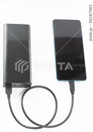power bank with charging cable and phone, copy space and white background. 99167963
