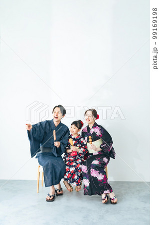 浴衣で屋台グルメを食べる親子 99169198