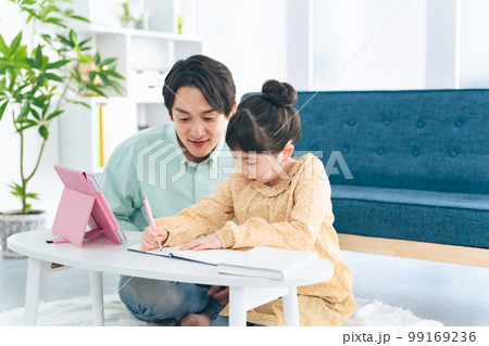 リビングで女の子に勉強を教える男性 99169236