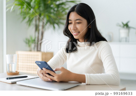 Asian woman using smartphone in morning at home Asian woman using smartphone in morning at home 99169633