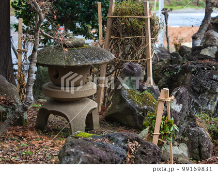 日本庭園の石灯籠と庭石と雪囲いされた庭木の写真素材 [99169831] - PIXTA