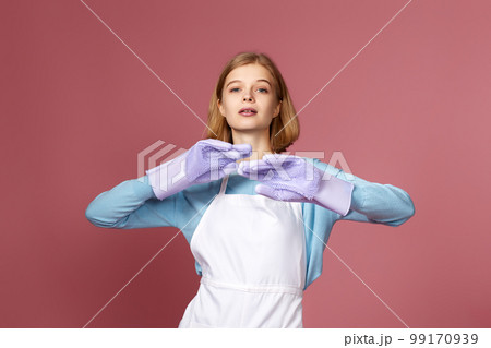 woman in gloves and cleaner apron on pink background. 99170939