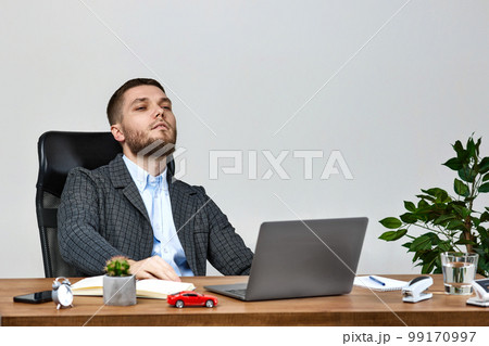 man sitting on chair at table and resting, using laptop man sitting on chair at table and resting, using laptop 99170997