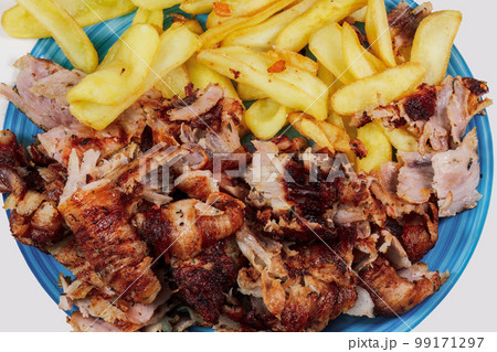 Greek gyros pork meat chopped portion served with fried potatoes on a dish close-up top view. Greek gyros pork meat chopped portion served with fried potatoes on a dish close-up top view. 99171297