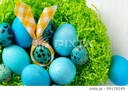 Blue painted eggs in a nest for Easter 99178149