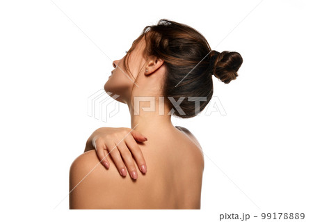 Side view image. Healthy back, massage. One beautiful brunette girl posing against white studio background. Concept of natural beauty 99178889