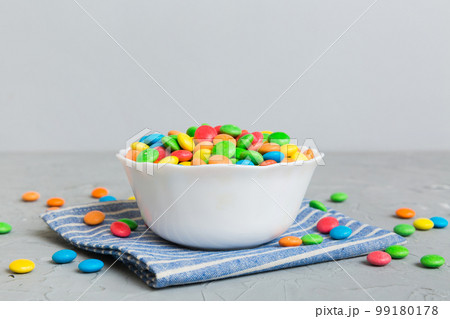 Multicolored candies in a bowl on a colored background. birthday and holiday concept. Top view with copy space Multicolored candies in a bowl on a colored background. birthday and holiday concept. Top view with copy space 99180178