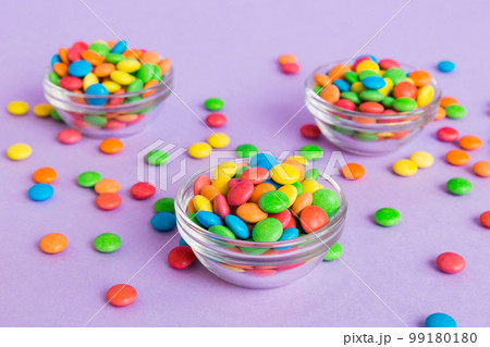 Multicolored candies in a bowl on a colored background. birthday and holiday concept. Top view with copy space 99180180