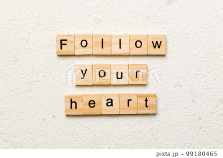 Follow your heart word written on wood block. Follow your heart text on cement table for your desing, Top view concept Follow your heart word written on wood block. Follow your heart text on cement table for your desing, Top view concept 99180465