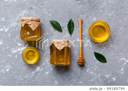 Honey jar with wooden honey dipper on white background top view with copy space. Delicious honey bottle 99180794
