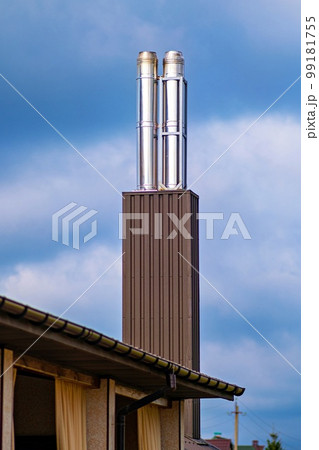 New modern chimney - two stainless steel pipes on a residential building. New modern chimney - two stainless steel pipes on a residential building. 99181755