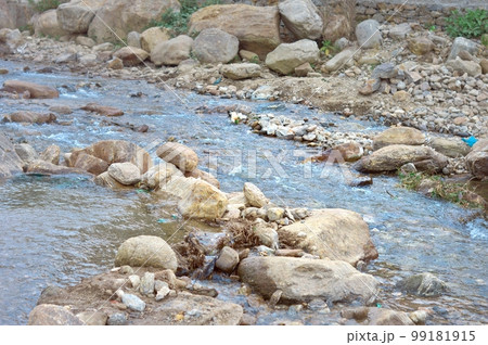 Rocky River mountain streams flowing through the rocks and pebbles of north east section of the Himalayan mountain ranges. Nature background. Close up. 99181915
