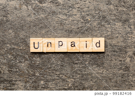 UNPAID word written on wood block. UNPAID text on cement table for your desing, concept 99182416