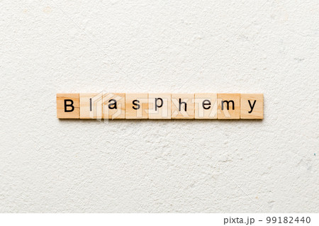 BLASPHEMY word written on wood block. BLASPHEMY text on cement table for your desing, concept 99182440