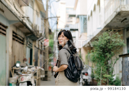 Young Asian woman backpack traveler enjoying street cultural local place and smile. Traveler checking out side streets. 99184130