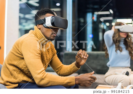 A black man exploring virtual reality in an office 99184215