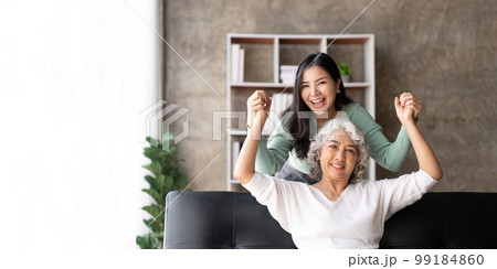 Happy daughter and mother having fun in living room, smiling mother hugging young grown daughter bonding chatting relaxing encourage each other at home together Happy daughter and mother having fun in living room, smiling mother hugging young grown daughter bonding chatting relaxing encourage each other at home together 99184860